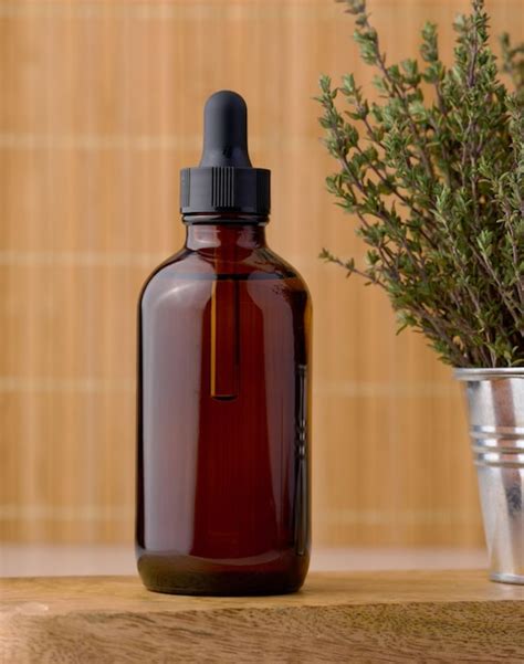 Premium Photo Thyme Essential Oil In Glass Bottle With Dropper And