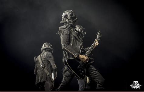 Two Men In Gas Masks Playing Guitars