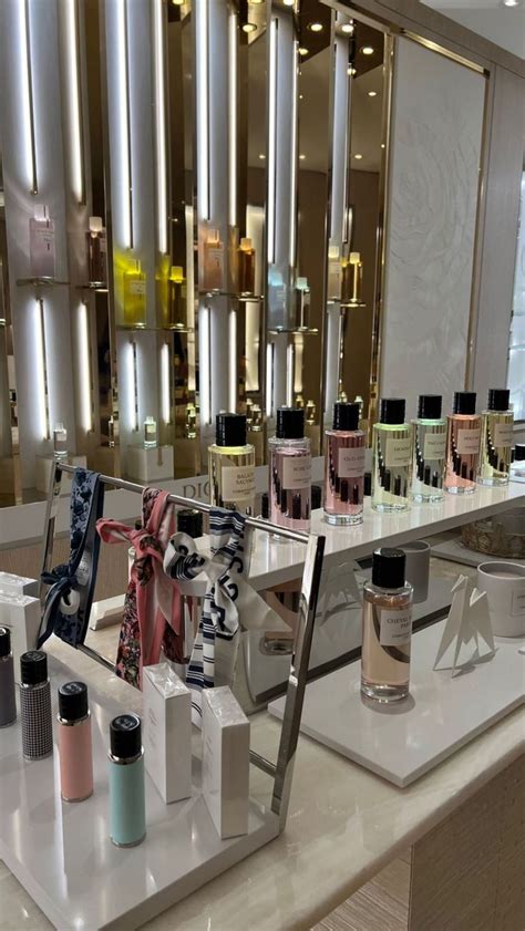 The Counter Is Full Of Perfumes And Other Items In Front Of A Large Mirror