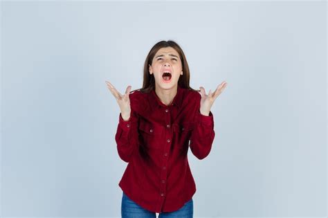 Portrait De Jeune Fille Levant Les Mains Tout En Criant En Chemise