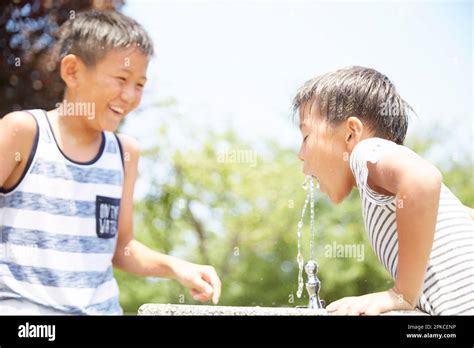 Boy drinking water at water fountain Stock Photo - Alamy