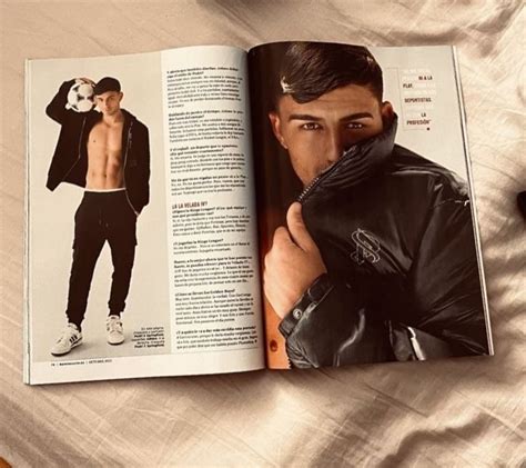 An Open Magazine With A Man In Black Clothes On Top Of A Bed Next To A