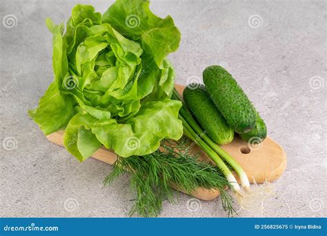 On A Wooden Board Head Of Green Lettuce Cucumbers Green Onions Dill