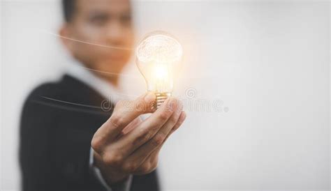 Concept Creativity With Light Bulbs And Energy Power Man Hand Holding