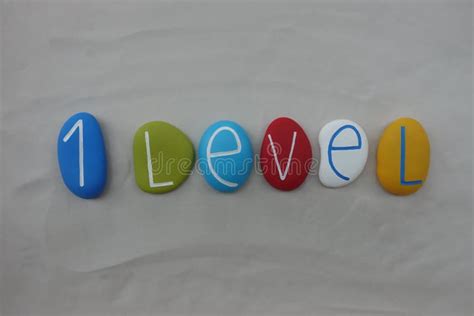 level text composed  multi colored stones  white sand