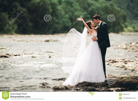 Beautifull Wedding Couple Kissing And Embracing Near The Shore Of A