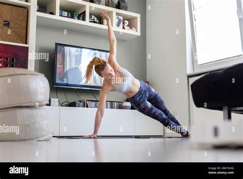 Attractive Sporty Woman Working Out At Home Doing Pilates Exercise In