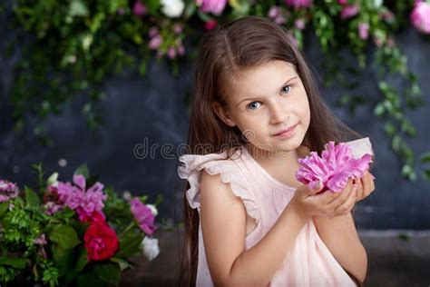 Portrait Of The Lovely Little Girl With A Bouquet Of Flowers Looking