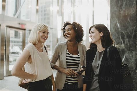 Happy Friends Talking While Standing In Cafe Stock Photo