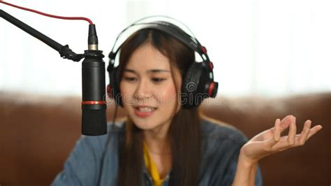 Asian Woman Radio Host Wearing Headphone And Talking Through Microphone