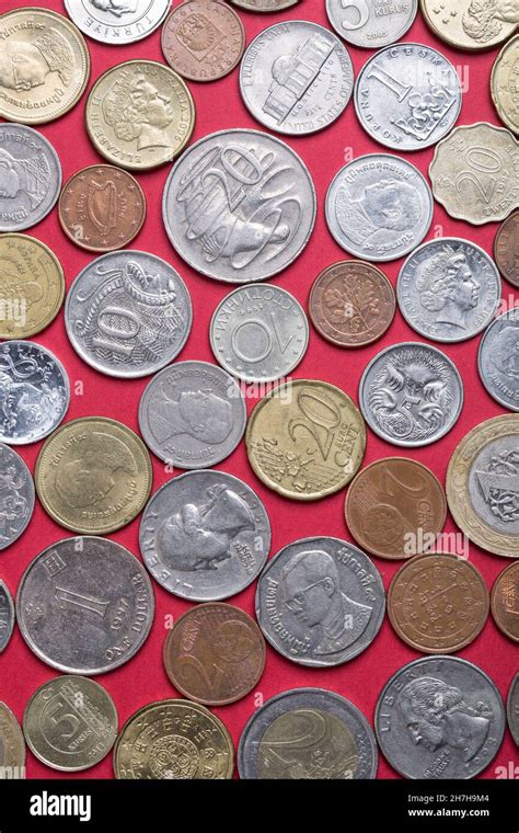 Coins of different countries on a red background Stock Photo - Alamy