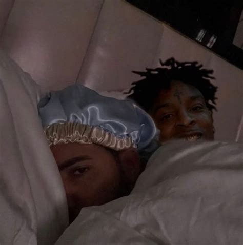 Two People Laying In Bed With White Sheets And Blankets On Their Heads