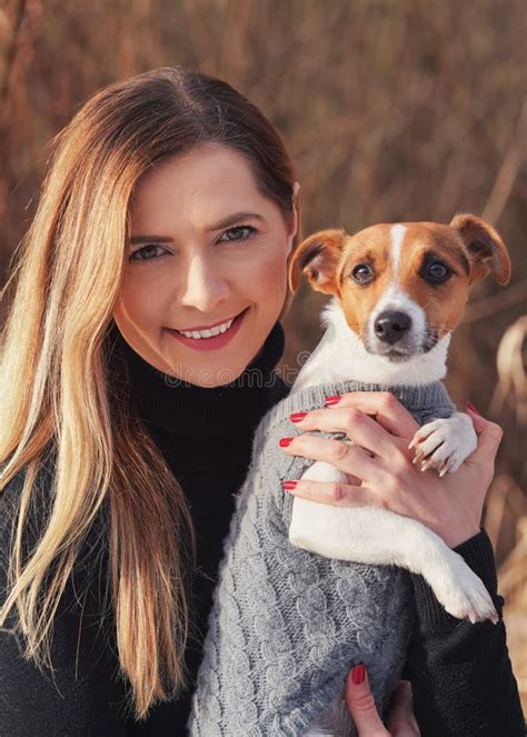 Young Woman Holding Her Jack Russell Terrier Dog Wearing Warm Winter