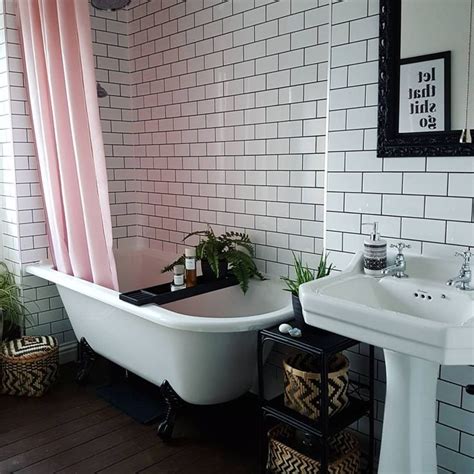 A Bath Tub Sitting Next To A White Sink Under A Bathroom Mirror With