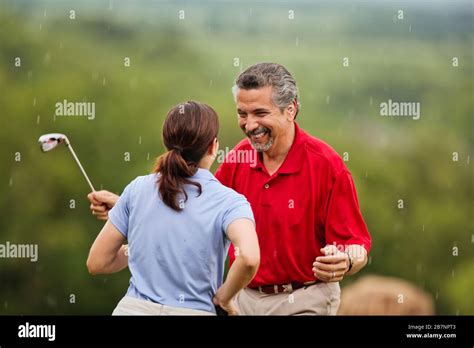 Happy Mature Couple Laugh Together As They Are Caught In A Sudden Rain