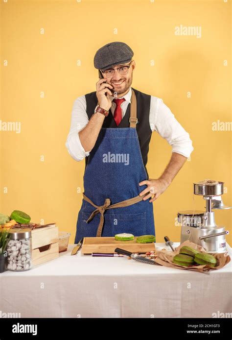 Burger Master in uniform and cap taking order using smart phone at his ...