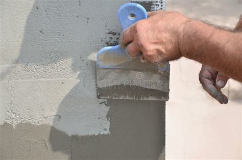 Hands Of An Old Manual Worker With Wall Plastering Tools Renovating