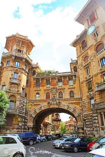 Cars Are Parked In Front Of An Old Building With A Stone Arch Over The