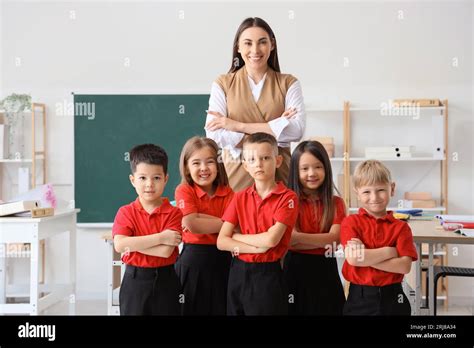 Female teacher with little school children in classroom Stock Photo - Alamy