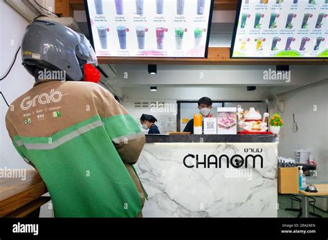 Grab food delivery moped driver waits for order in bubble tea cafe ...