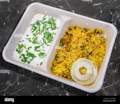 Vegetable Biryani with Raita on a take away container Stock Photo - Alamy