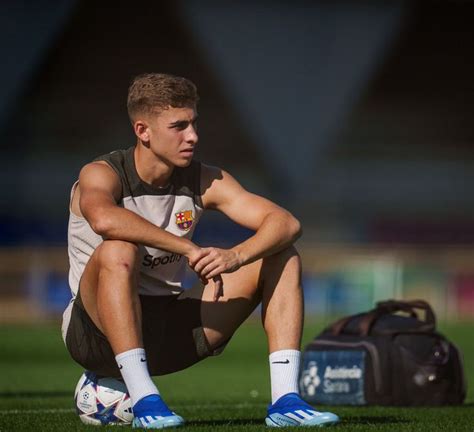 A Man Sitting On Top Of A Soccer Field Next To A Bag With His Hand On