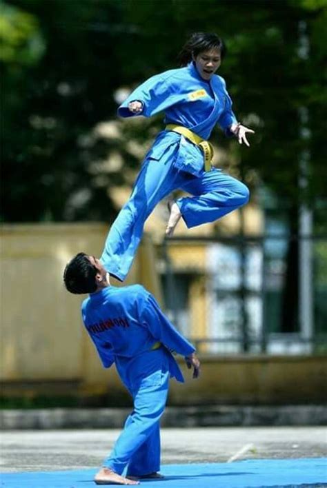 Two People Doing Tricks On A Blue Mat