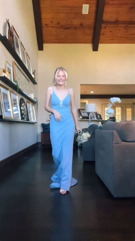 A Woman In A Long Blue Dress Standing In A Living Room