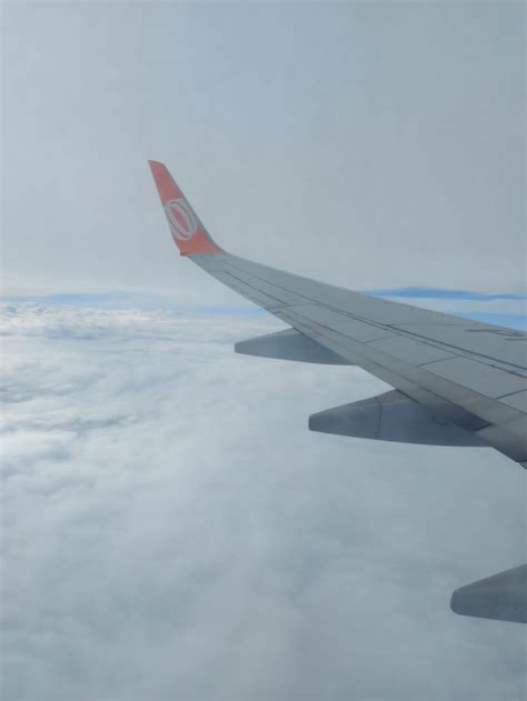 The Wing Of An Airplane Flying Above The Clouds