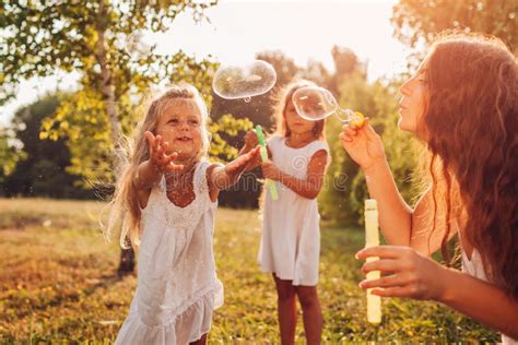 M Re Aide Les Filles Faire Exploser Des Bulles Dans Le Parc D T