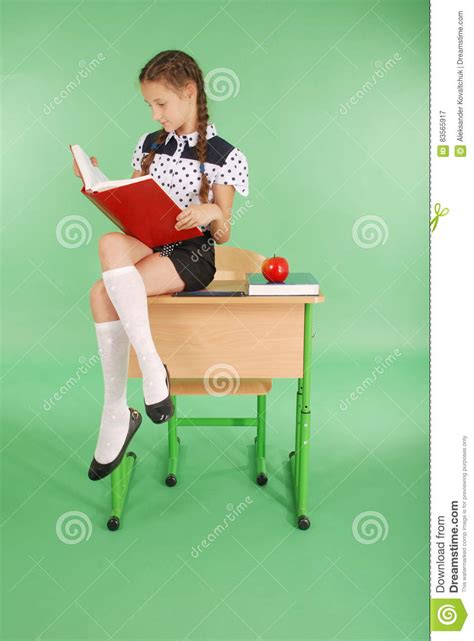 Fille Dans Un Uniforme Scolaire Se Reposant Sur Le Bureau Et Lisant Un