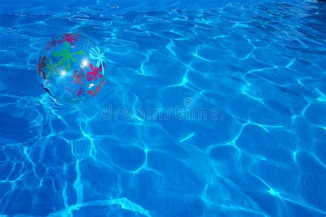 Pelota De Playa Que Flota En Una Piscina Azul Fondo Del Verano Imagen