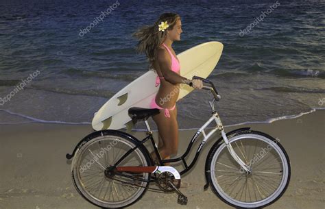 Girl In Pink Bikini Riding Her Bike On The Beach Stock Photo