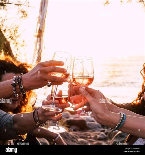 people drinking at party outdoor. group of friends white wine in hand ...