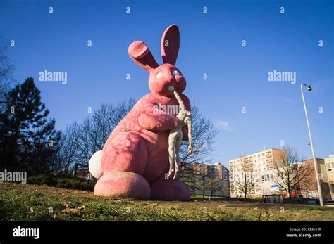 giant pink rabbit eating a headless human body statue Stock Photo - Alamy