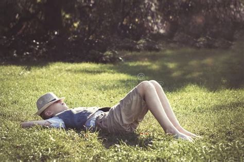 Kid lying on green grass stock image. Image of joyful - 158228869