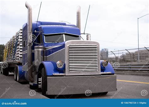 Bright Blue Big Rig Semi Truck With Flat Bed Trailer Transporting