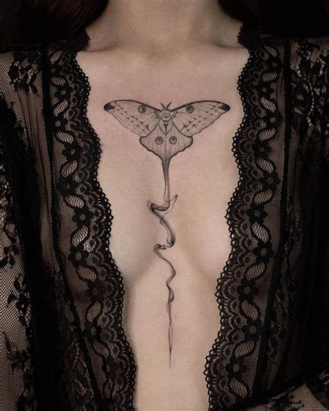 A Woman S Chest With A Moth Tattoo On Her Stomach And An Arrow In The