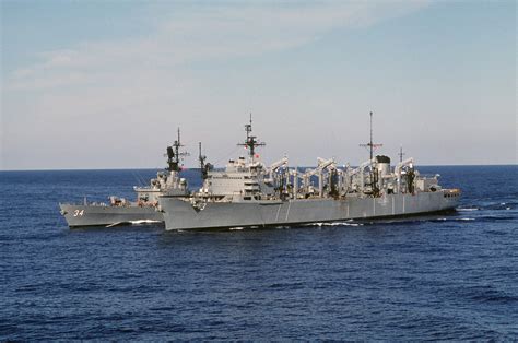 A port bow view of the fast combat support ship USS SEATTLE (AOE 3), right, participating in an ...