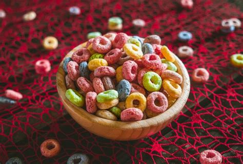 Premium Photo Colorful Round Fruit Cereals Scattered On Brown Wooden