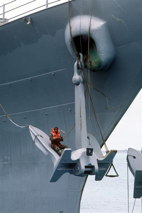 A Crew Member Paints The Anchor Of The Battleship Uss Missouri Bb