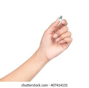 Hand Holding Pill Between Thumb Forefinger Stock Photo