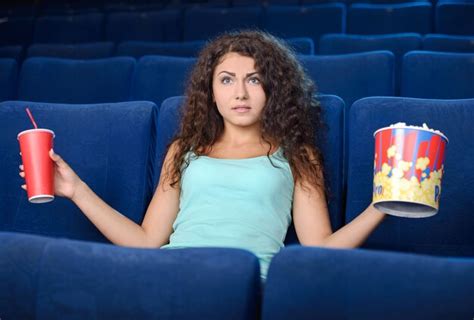 Premium Photo Beautiful Woman Eating Popcorn While Watching Movie