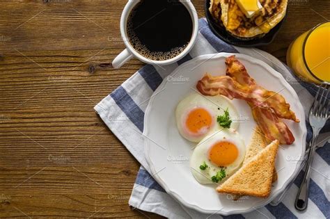 An English Breakfast With Eggs Bacon And Toast On A White Plate Next