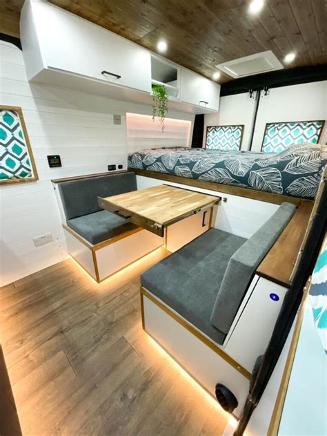 The Interior Of A Camper With Couches And Tables On Its Sides