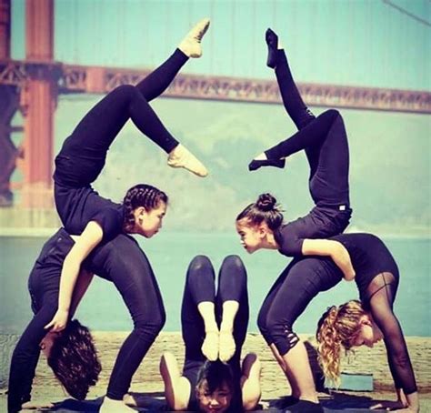 Four Women Doing Yoga Poses In Front Of The Golden Gate Bridge With