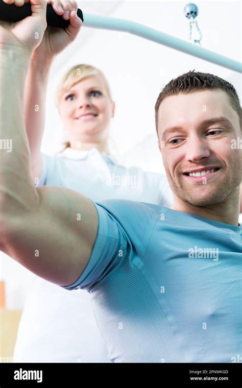 Patient At The Physiotherapy Doing Physical Exercises With Therapist In