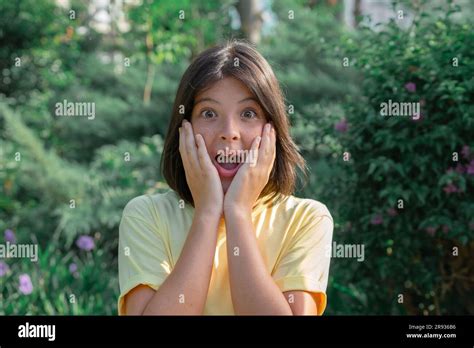 Frightened Young Girl With Wide Open Eyes The Girl Covered Her Face With Her Hands While