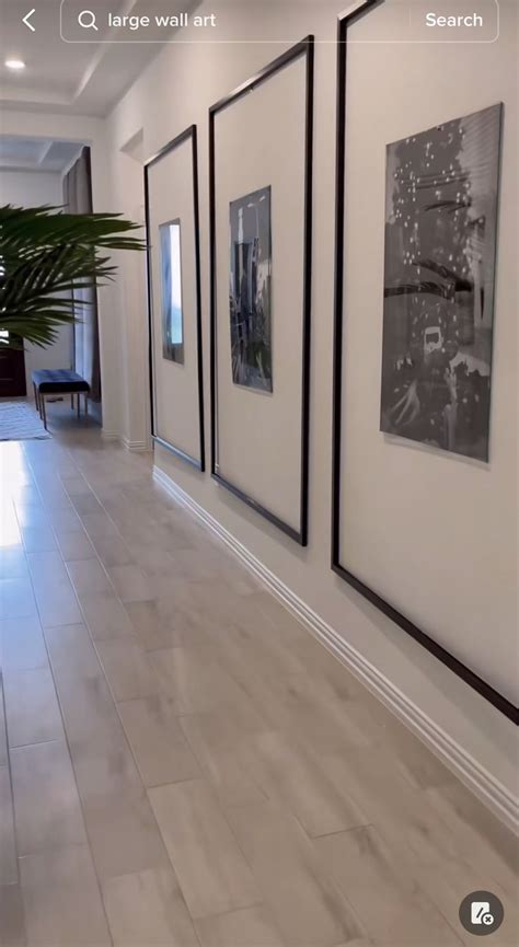 Three Black And White Pictures Hanging On The Wall Next To A Potted