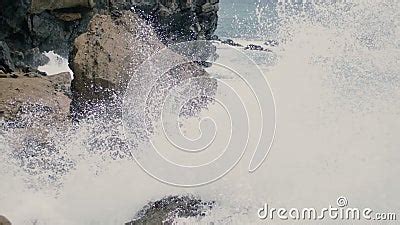 A Rocky Shore In The Ocean With Stormy And Foamy Waves Crashing Against